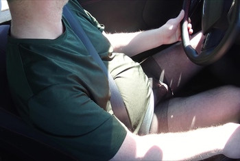 Nylonjunge fährt Auto in schwarzer Feinstrumpfhose